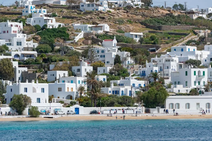 Whitewashed houses above a harbour beach on a Greek island